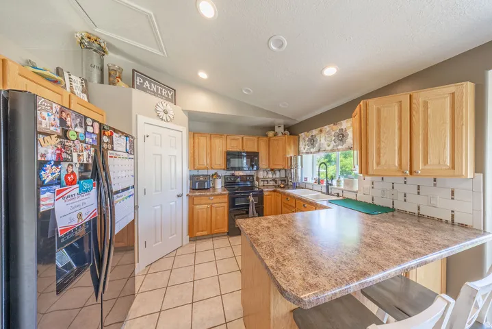Kitchen featuring wood-finish cabinetry, a patterned countertop, and tile flooring
