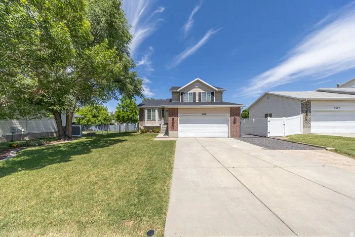 Two-story residence featuring a brick and siding exterior, an attached two-car garage, and a concrete driveway
