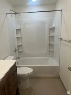 Contemporary bathroom featuring a white bathtub and shower surround with integrated shelving