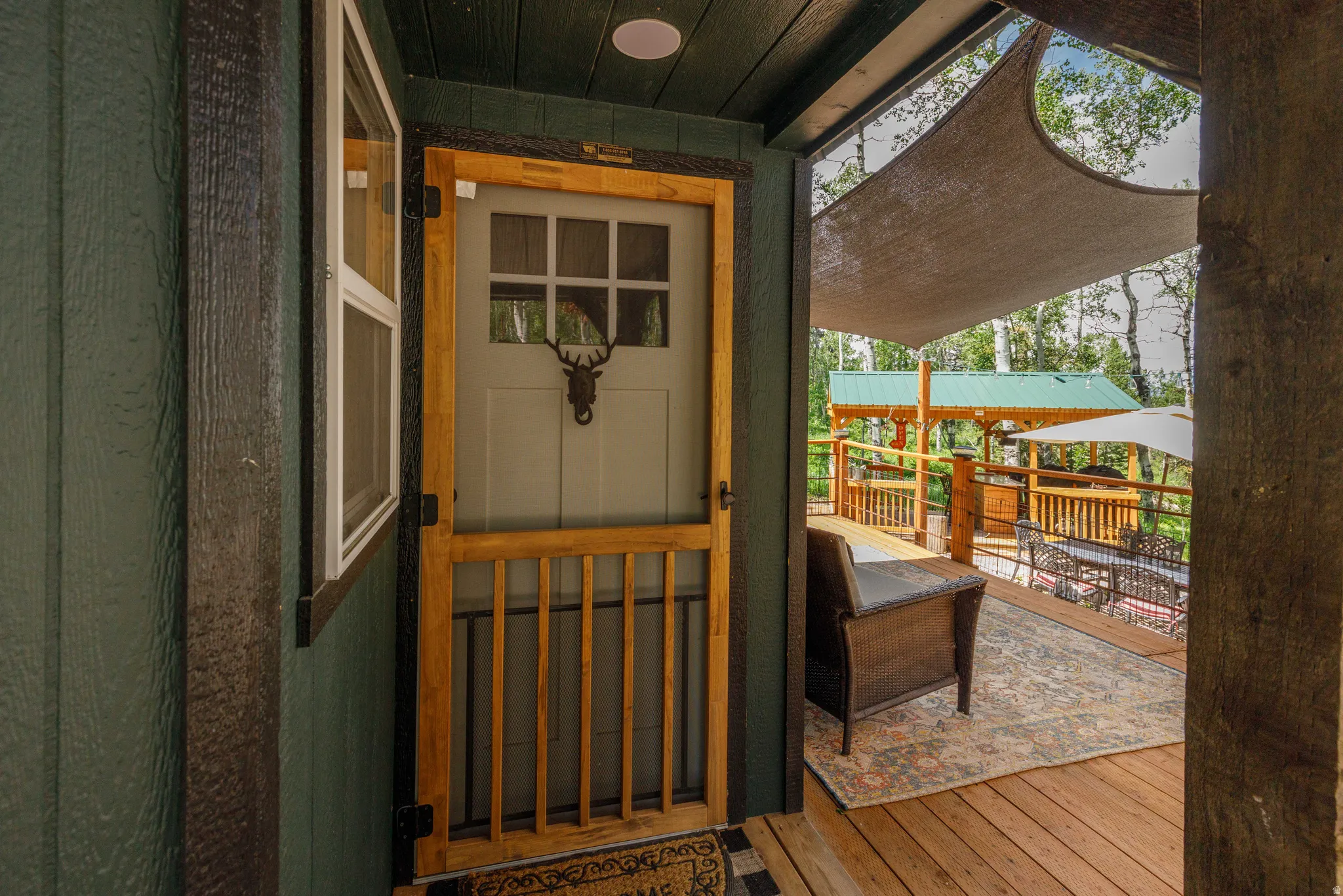 Deck with wood-finish flooring, a built-in pergola, and a shade sail