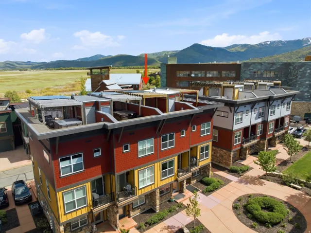Modern townhome exteriors featuring varied siding colors, stone accents, and multiple balconies