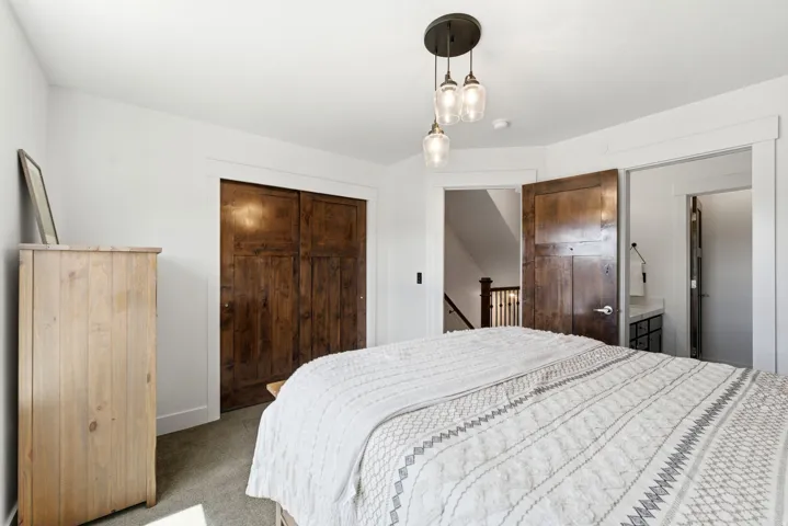 Room featuring dark wood-finish doors, white trim, and a three-light pendant fixture