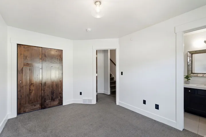 Room featuring plush gray carpeting, white walls, and a ceiling light fixture