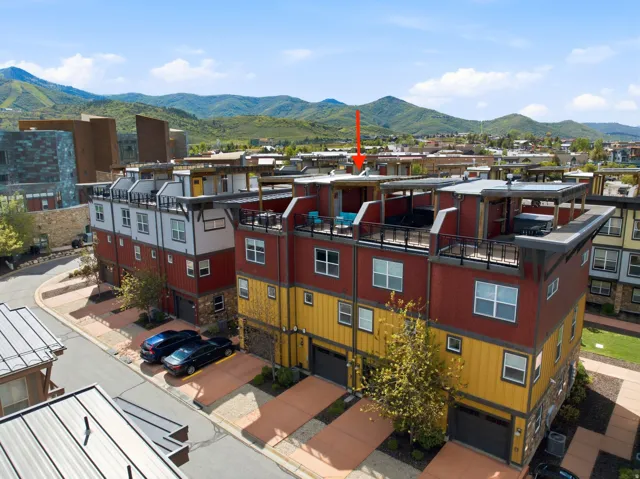 Modern multi-story townhouse featuring a flat roofline with a rooftop deck