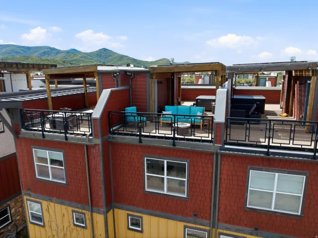 Rooftop deck featuring black metal railings and overhead pergola structures