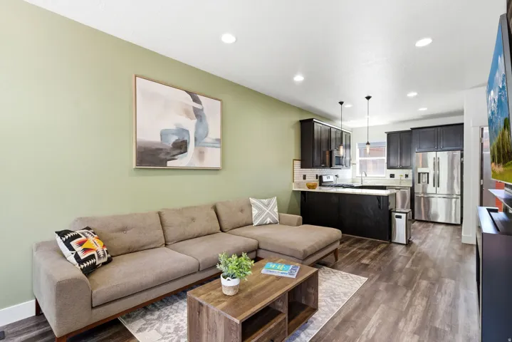Open-concept living area featuring wood-finish flooring, recessed lighting, and a neutral color palette