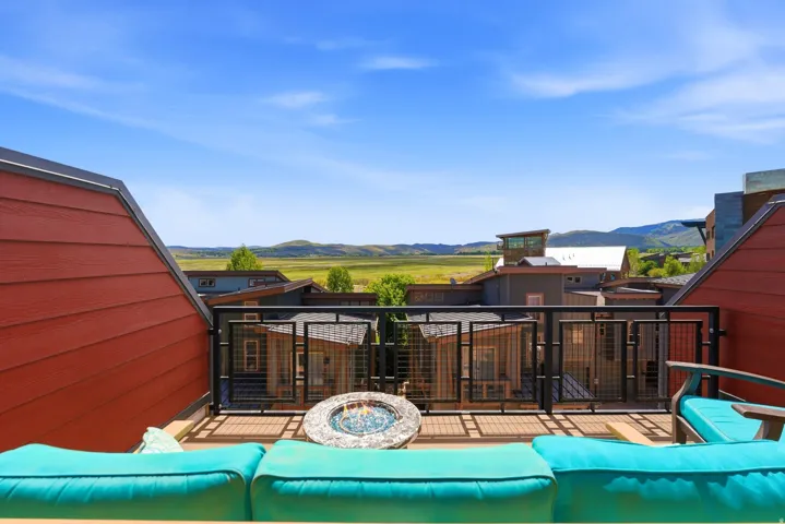 Outdoor deck featuring a built-in fire pit, composite decking, and a metal railing system