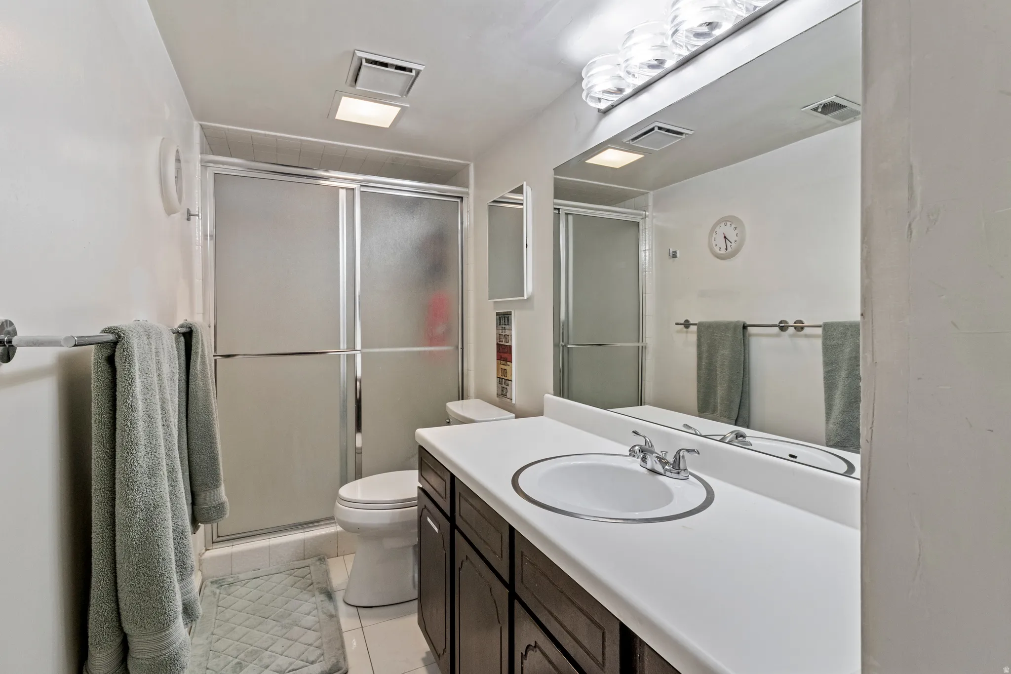 Bathroom featuring a dark wood-finish vanity with a white countertop and integrated sink