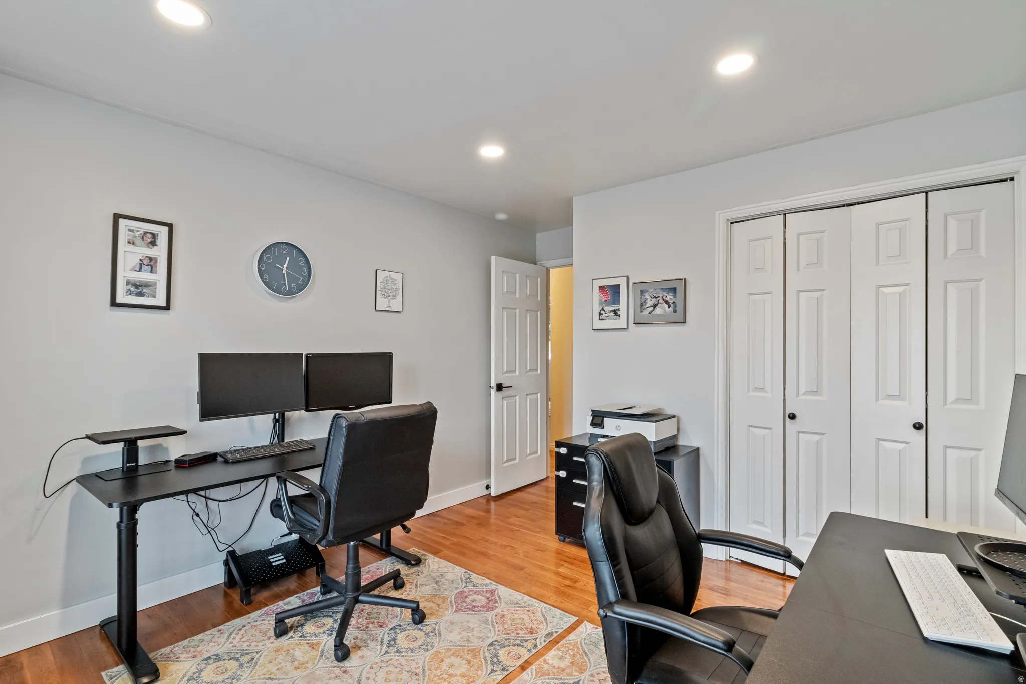 Versatile room featuring recessed lighting, light gray walls, wood-finish flooring, and white bi-fold closet doors