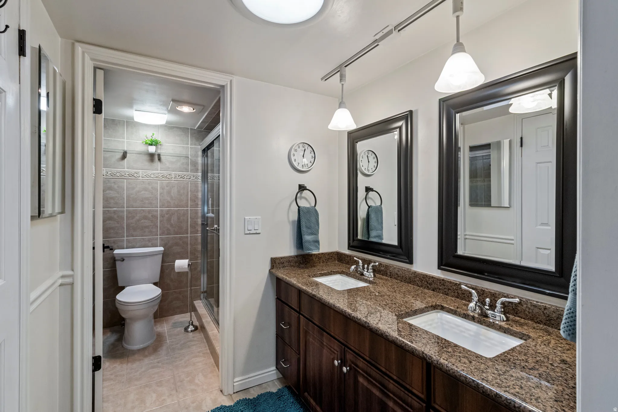 Dual vanity with integrated sinks, speckled countertop, and wood-finish cabinetry