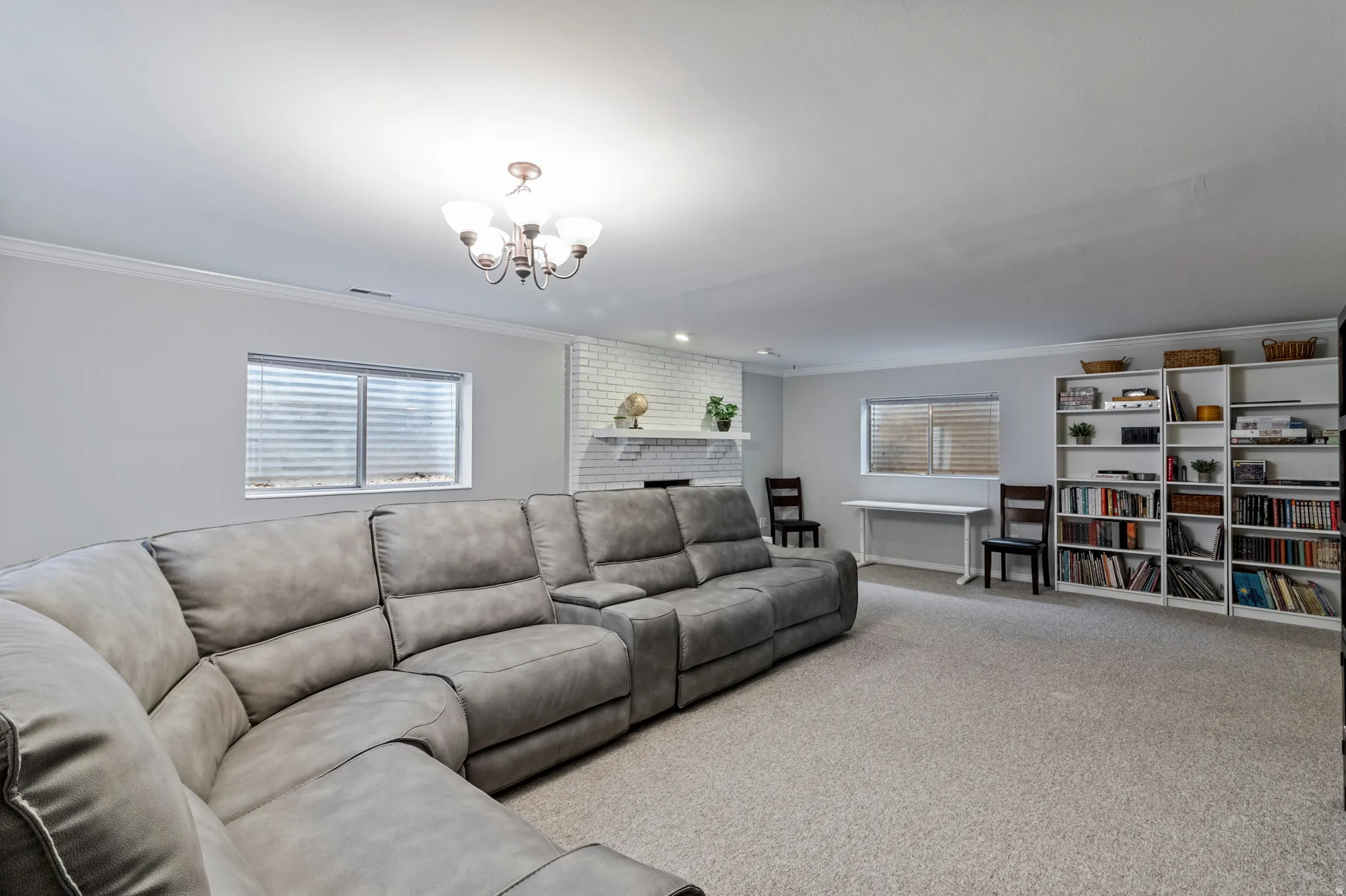 Spacious room featuring light gray walls, white trim, and light-toned carpet flooring