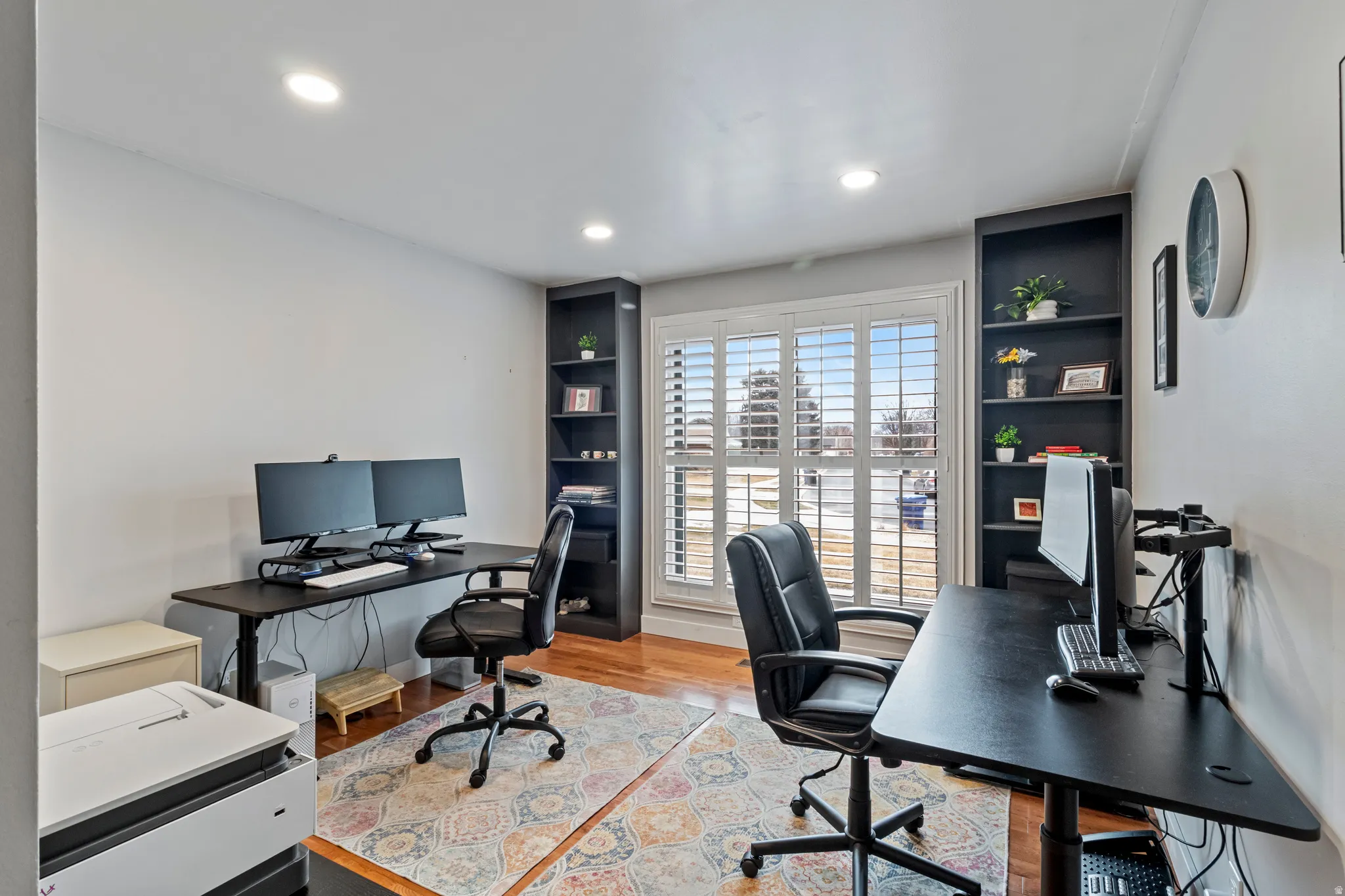 Functional room featuring wood-finish flooring and recessed ceiling lights