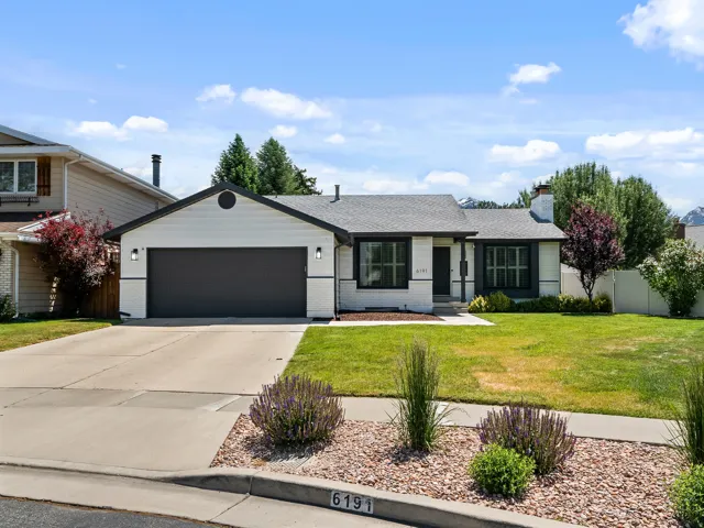 White exterior with black trim, a dark gray garage door, and a light gray roof