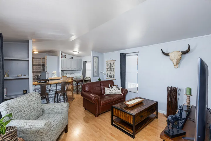 Open-concept living area featuring wood-finish flooring, light-toned walls, and a built-in shelving unit