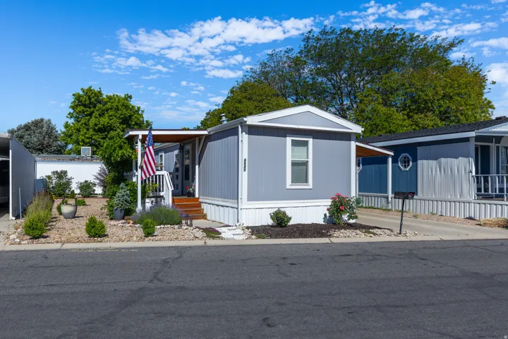 Light blue manufactured home with white trim and a covered entry porch