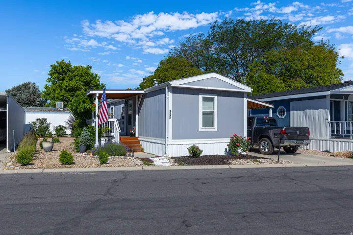Single-story manufactured home featuring light gray siding and white trim