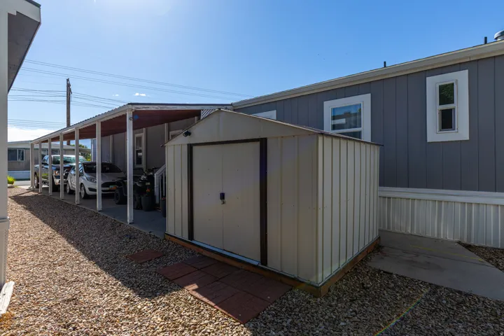 Attached storage shed featuring a metal exterior and double doors