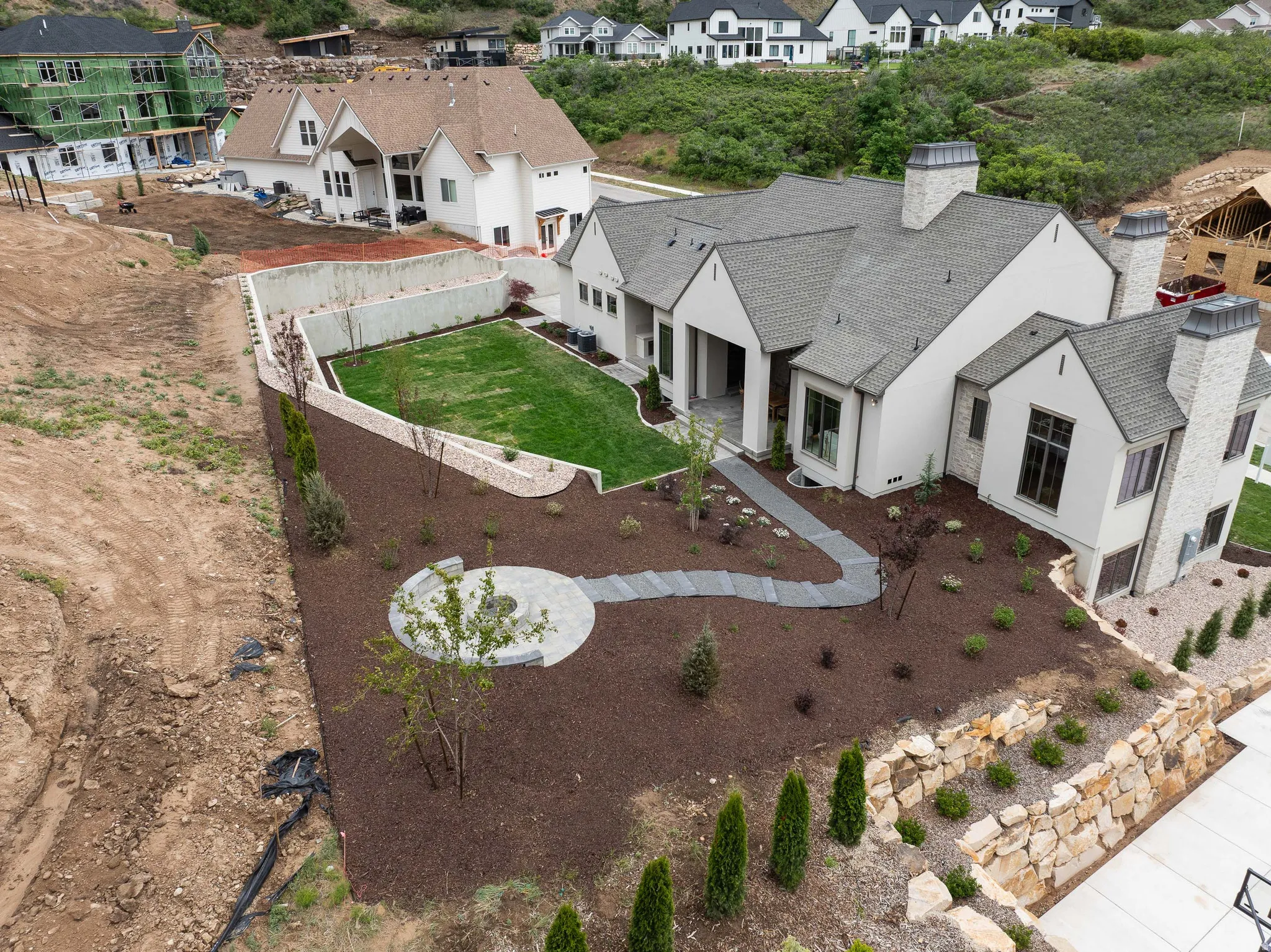 Contemporary residence featuring a light-toned exterior, stone accents, and multiple gabled rooflines