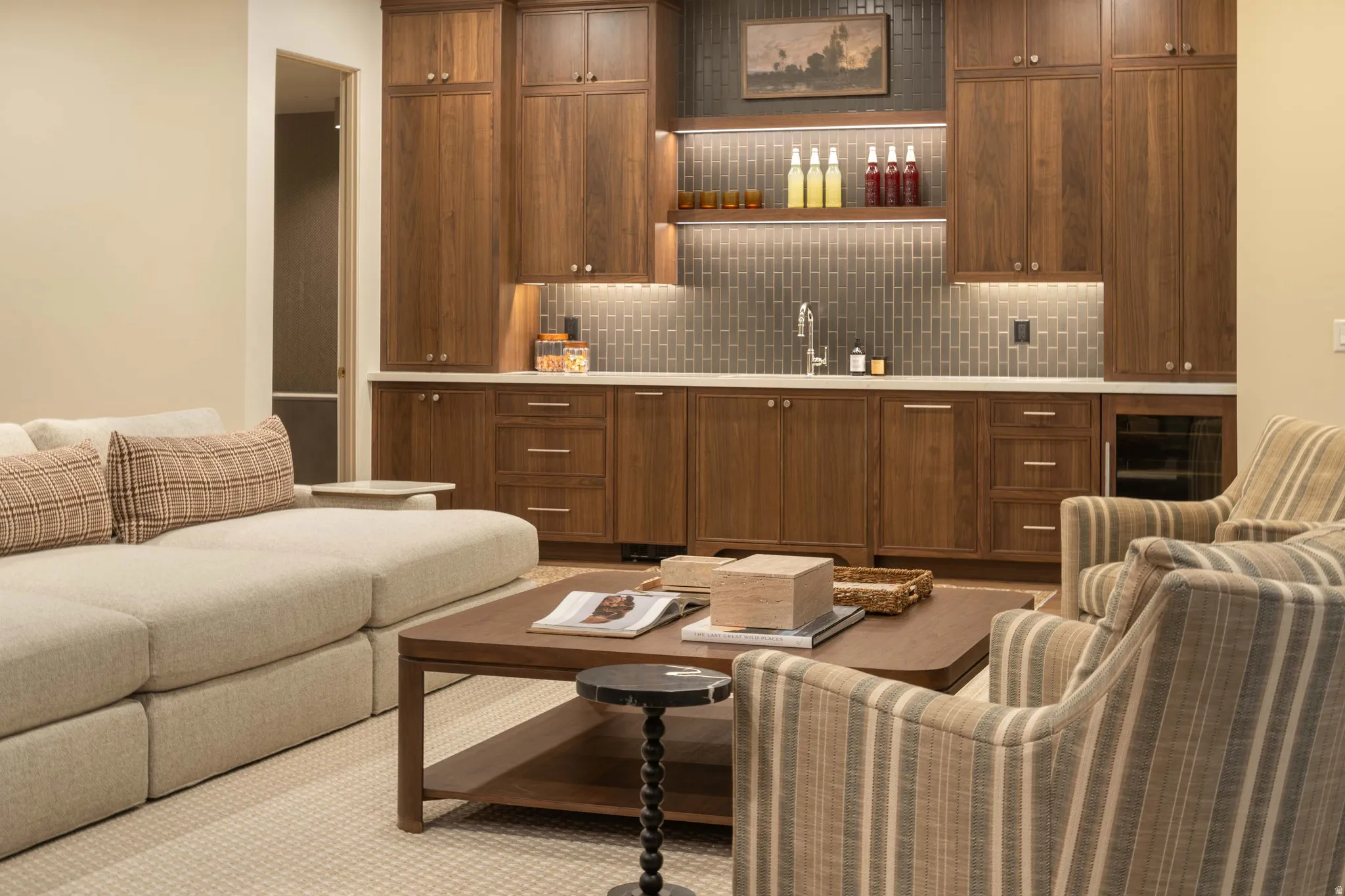 Built-in wet bar featuring rich wood-finish cabinetry, a subway tile backsplash, under-cabinet lighting, and a beverage refrigerator