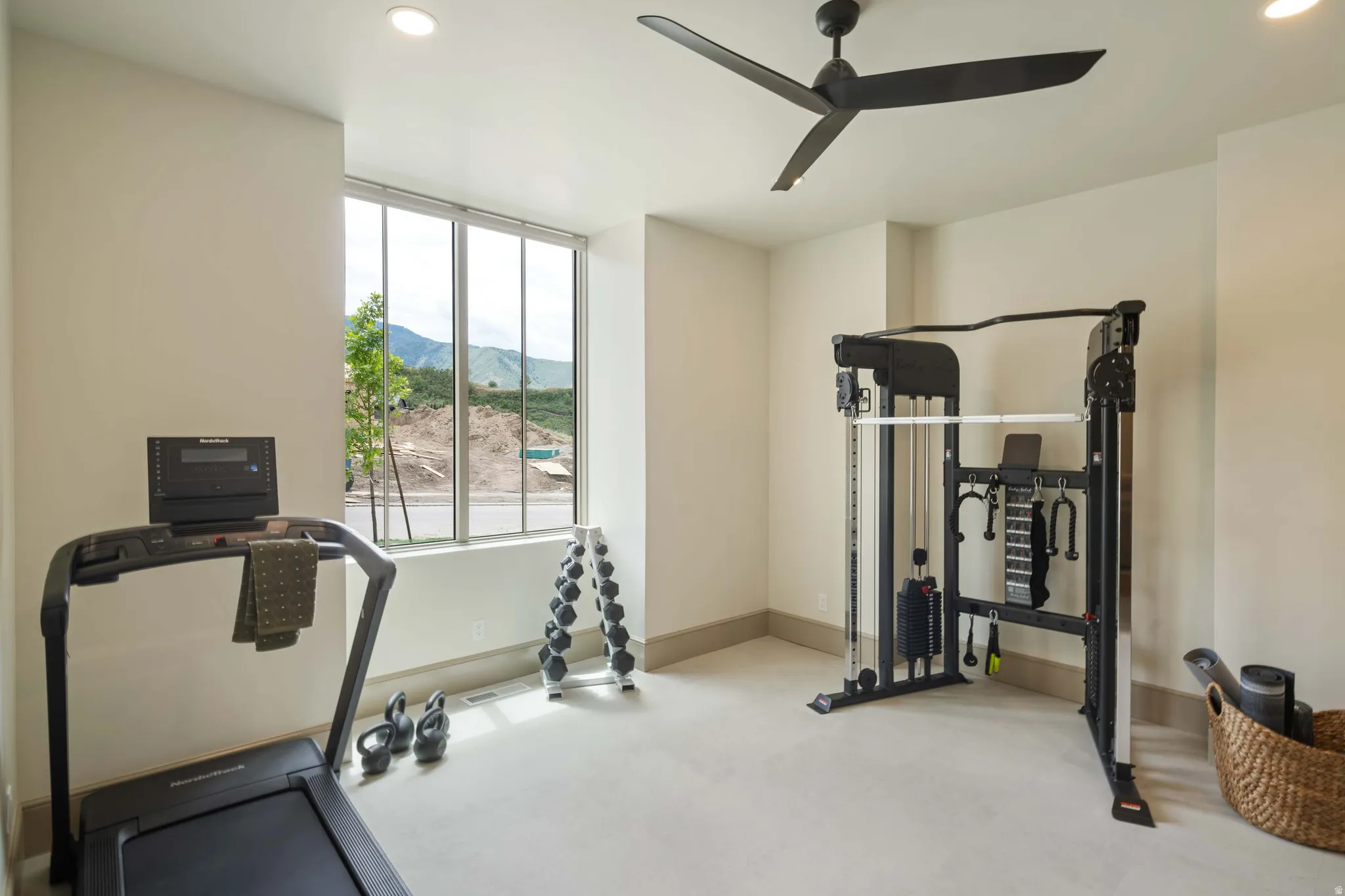 Bright interior space featuring a large window, recessed lighting, and a dark-toned ceiling fan