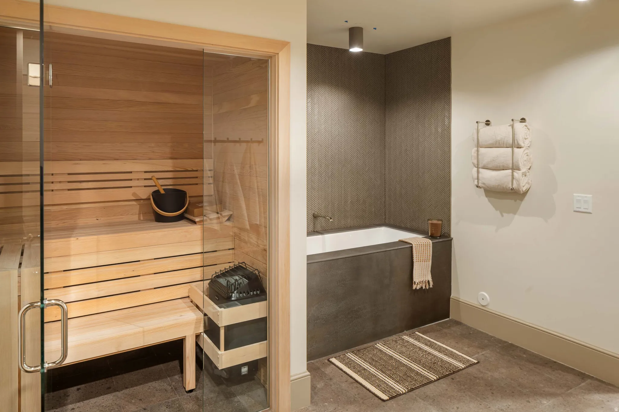 Glass-enclosed sauna with natural wood paneling and tiered seating