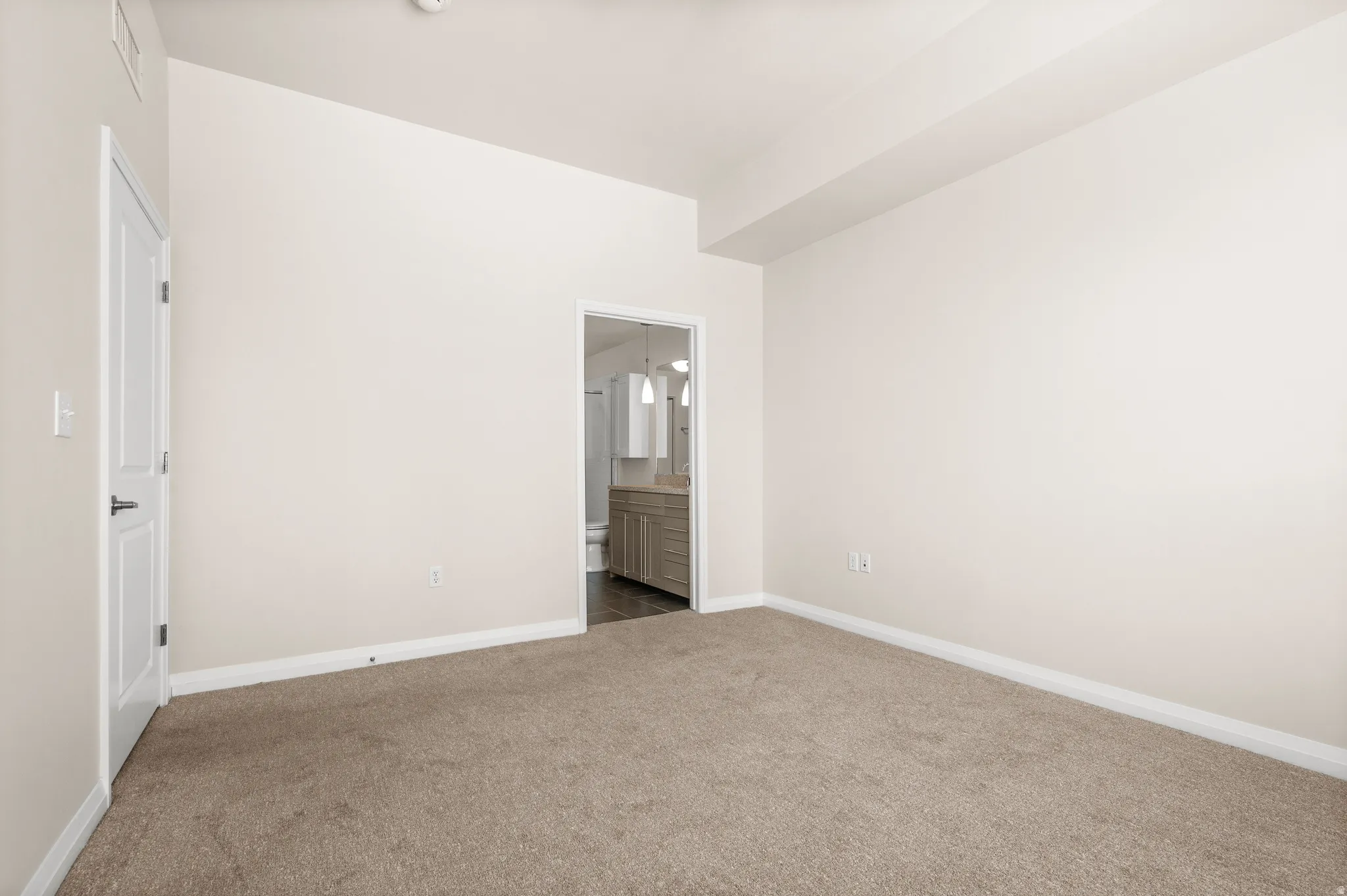 Bedroom featuring neutral carpeting, light-toned walls, and white trim