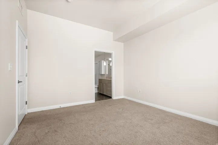 Bedroom featuring neutral carpeting, light-toned walls, and white trim