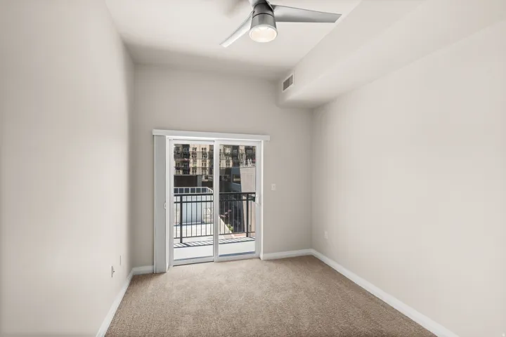 Room featuring neutral-toned carpeting, light-painted walls, and a contemporary ceiling fan with integrated lighting