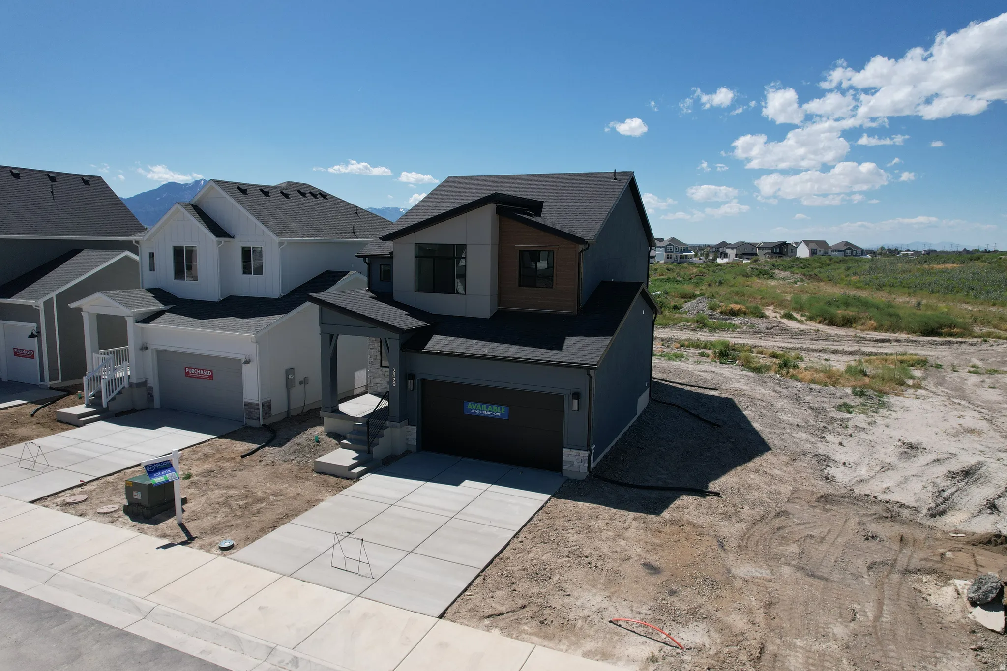 Modern contemporary exterior featuring dark siding, stone accents, and wood-finish paneling