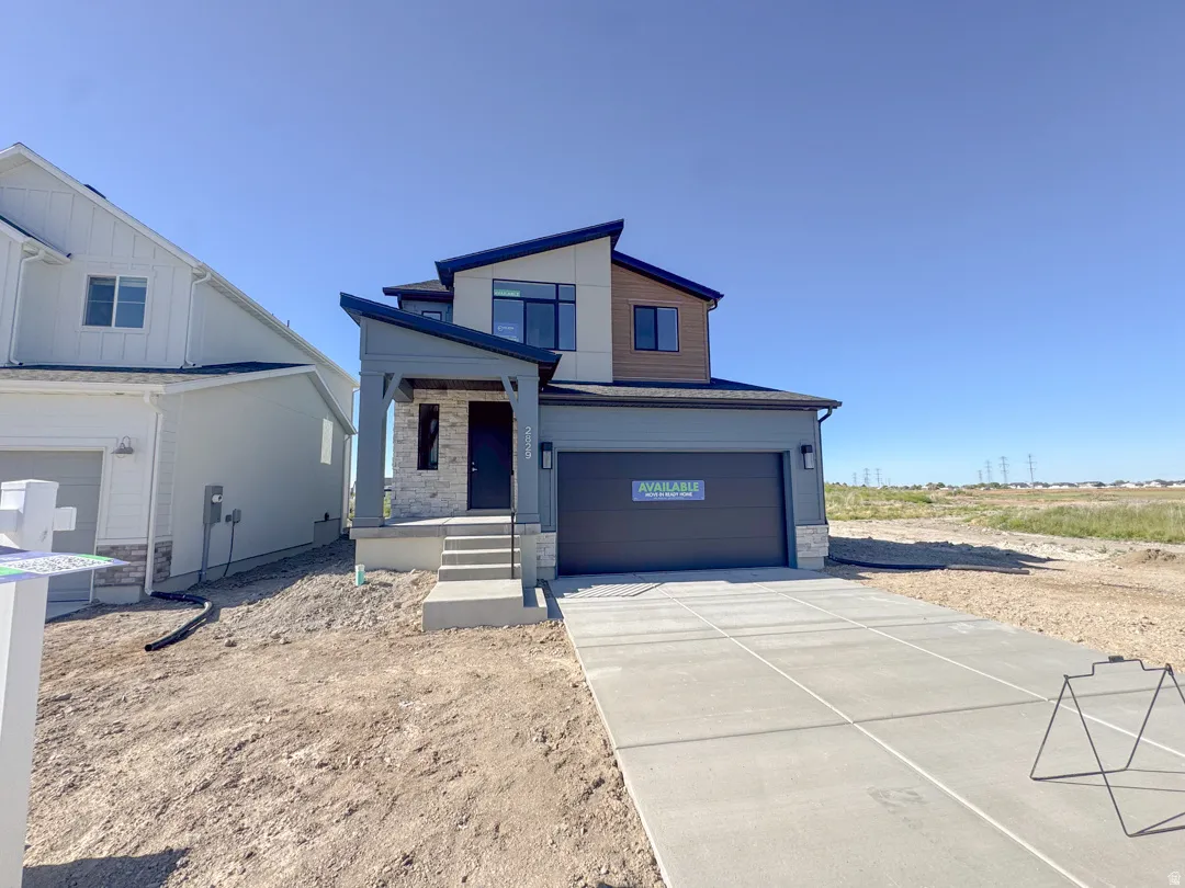 Contemporary-style residence featuring a multi-textured exterior with light stone accents, wood-finish siding, and dark trim