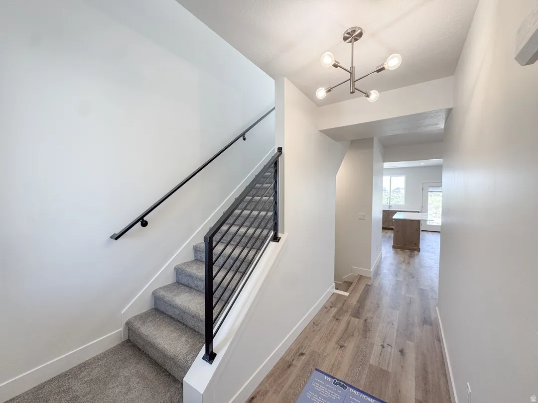 Entryway featuring a modern chandelier and wood-finish flooring