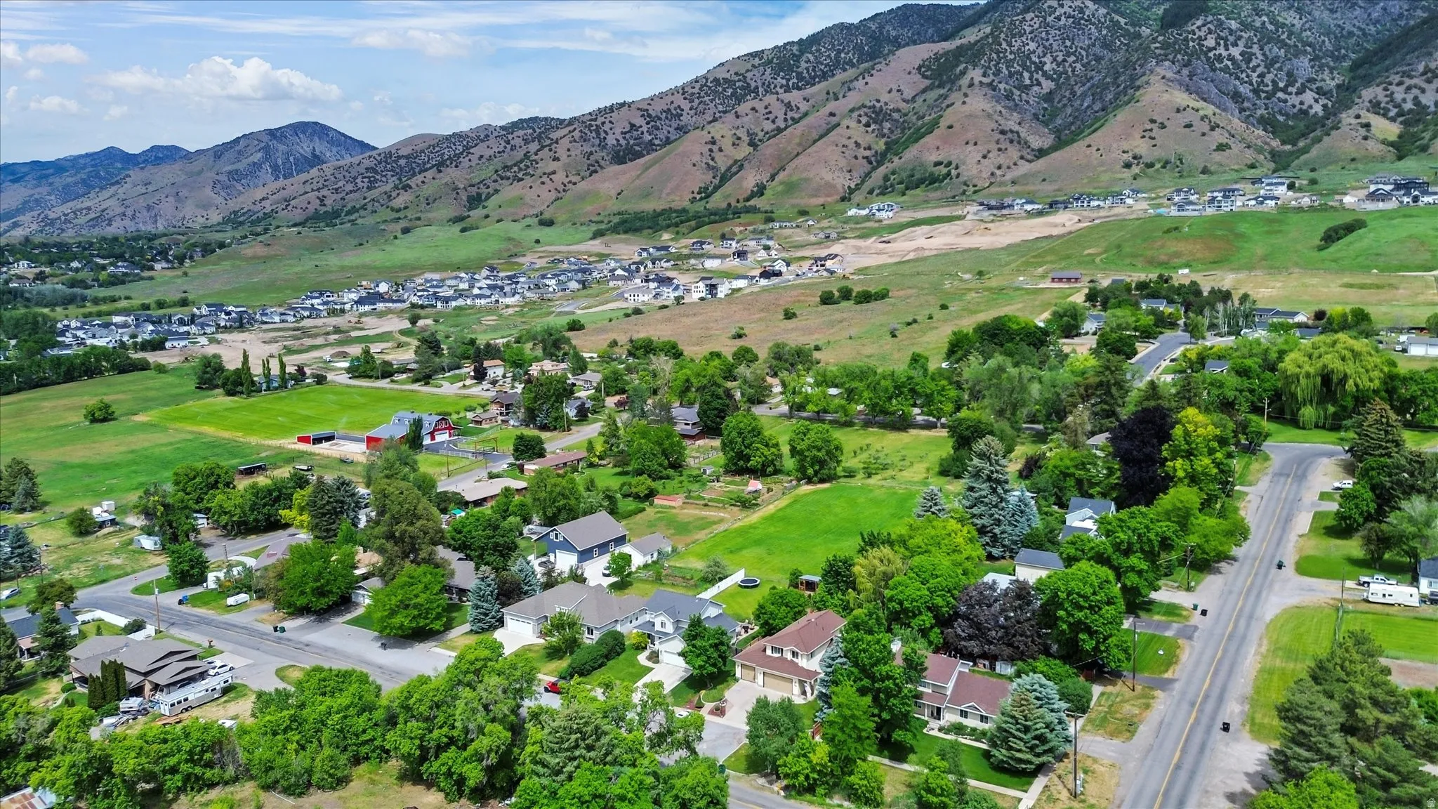 Expansive mountain backdrop framing a residential area with mature trees and varied architectural styles