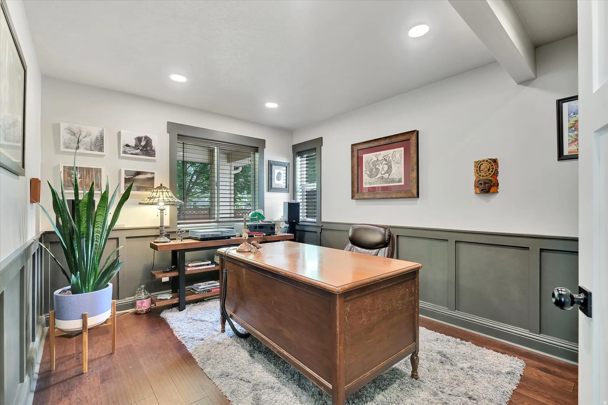 Dedicated room featuring wood-finish flooring, two-tone wall paneling, recessed lighting, and a window with blinds
