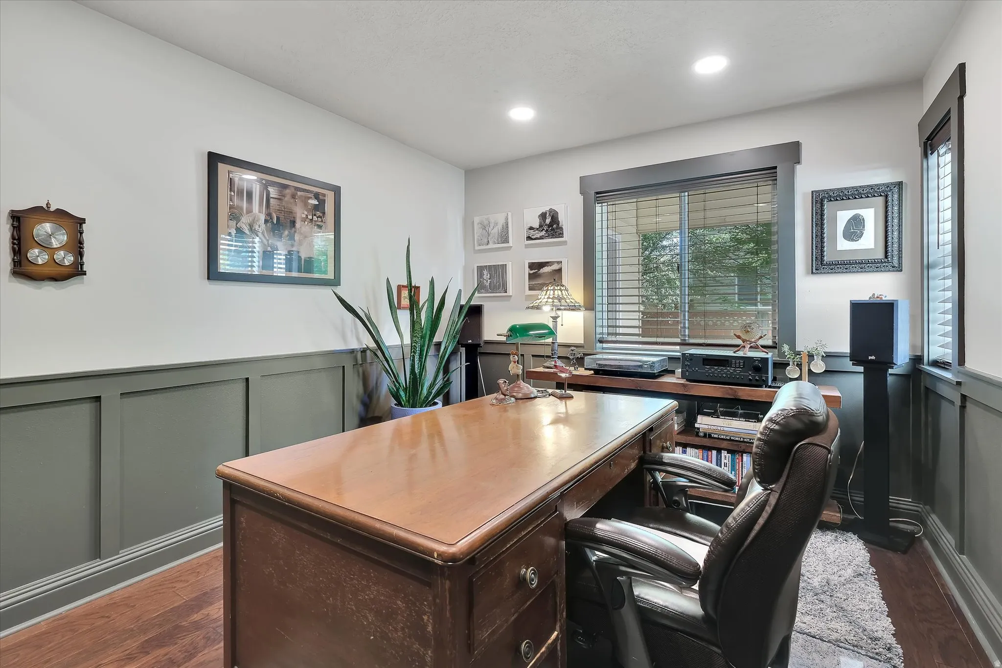 Room featuring wood-finish flooring, two-tone wall treatment with a paneled wainscoting, recessed ceiling lighting, and a window with blinds