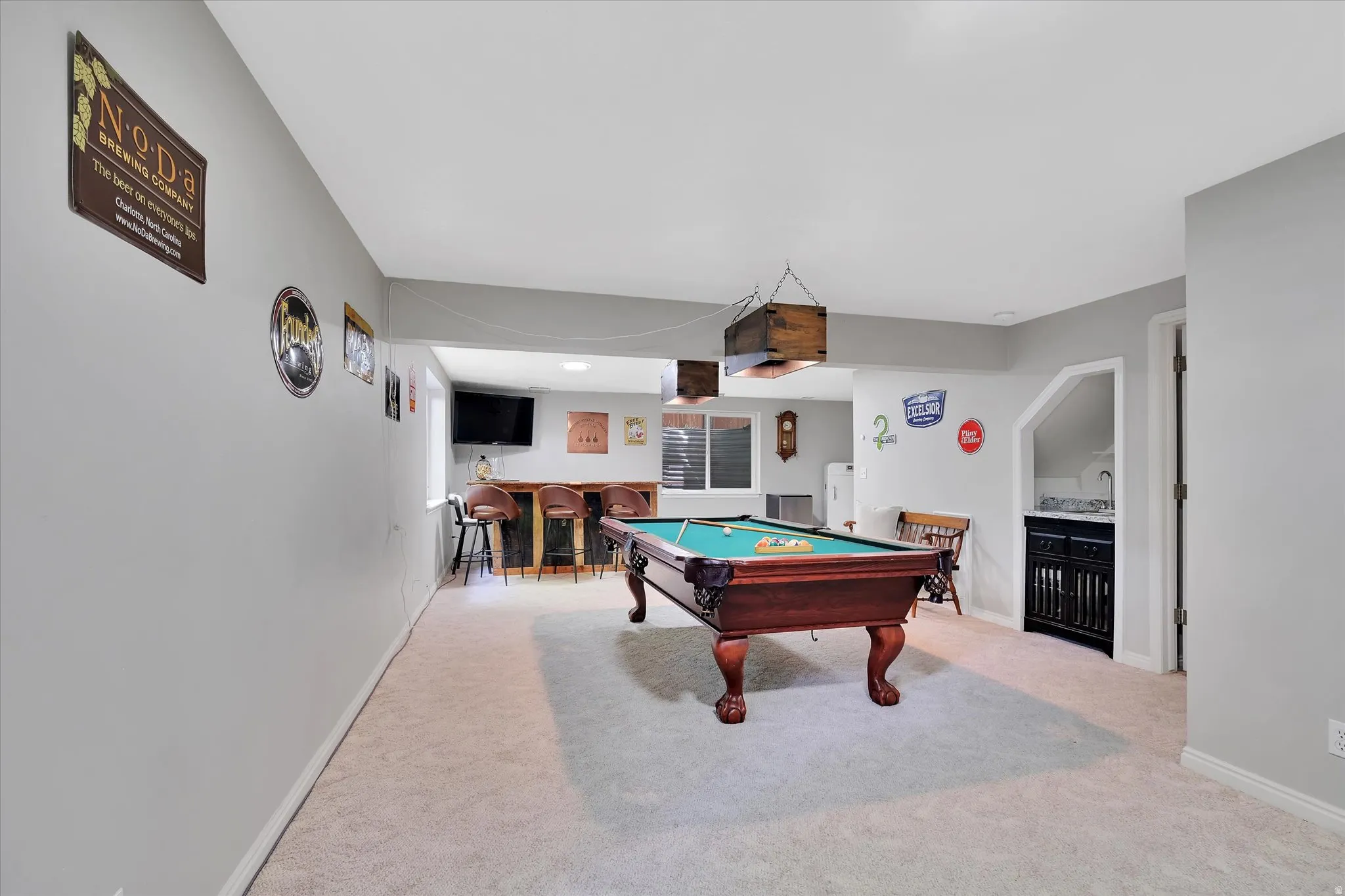 Recreation room featuring a pool table, built-in wet bar, and neutral carpeting