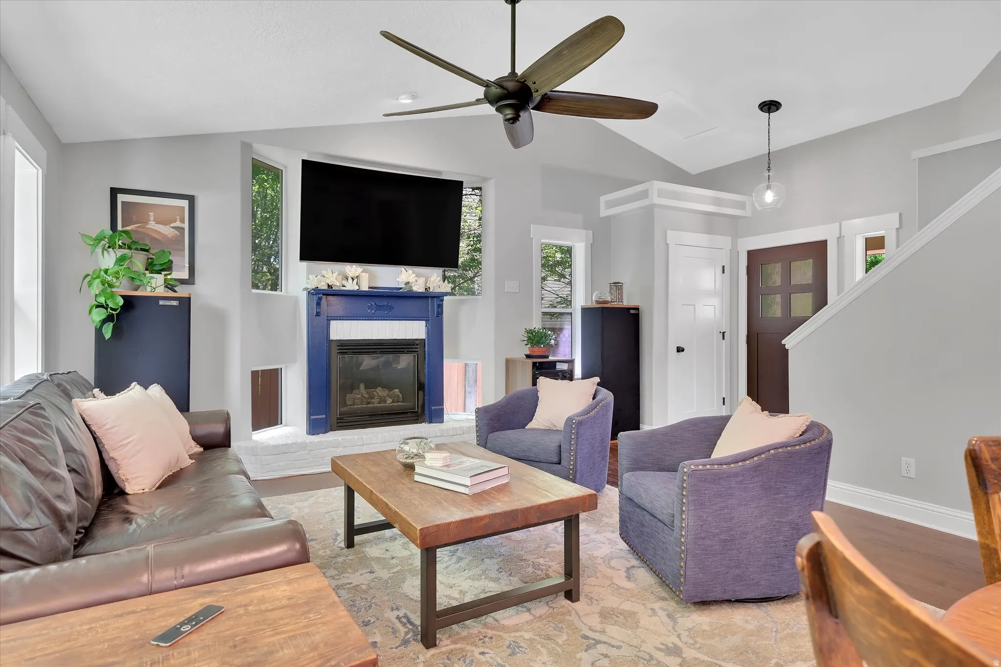 Living space featuring a striking blue fireplace mantel set against a white brick hearth