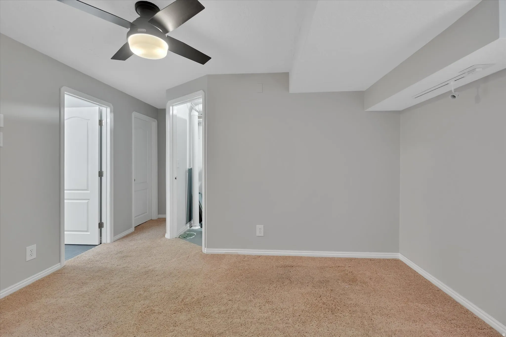 Carpeted room with light gray walls and white trim