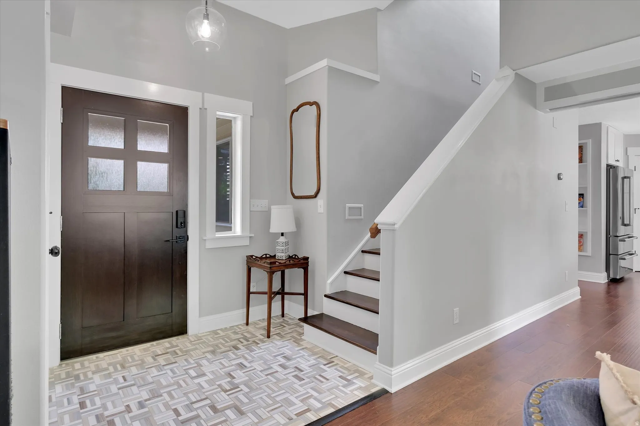 Entryway featuring a dark wood door with frosted glass panels, an adjacent sidelight window, and a geometric tile floor