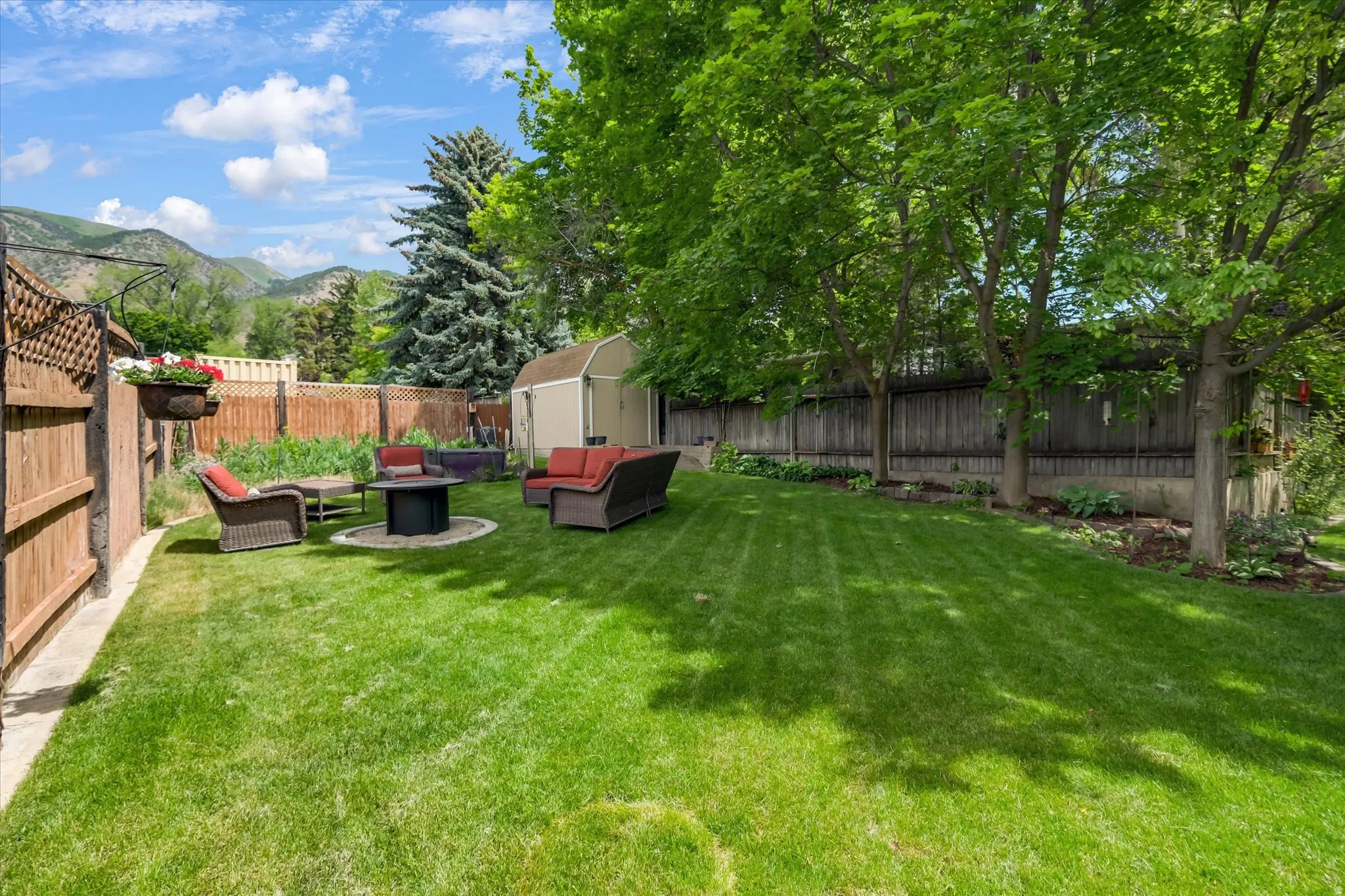 Expansive green lawn with mature trees and perimeter fencing