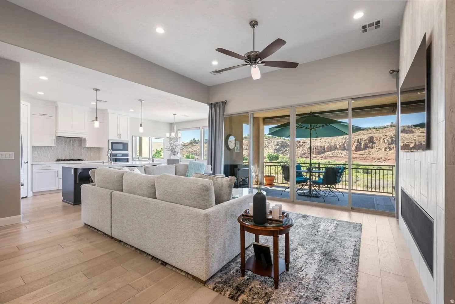 Open-concept living space featuring wood-finish flooring, recessed lighting, and a ceiling fan