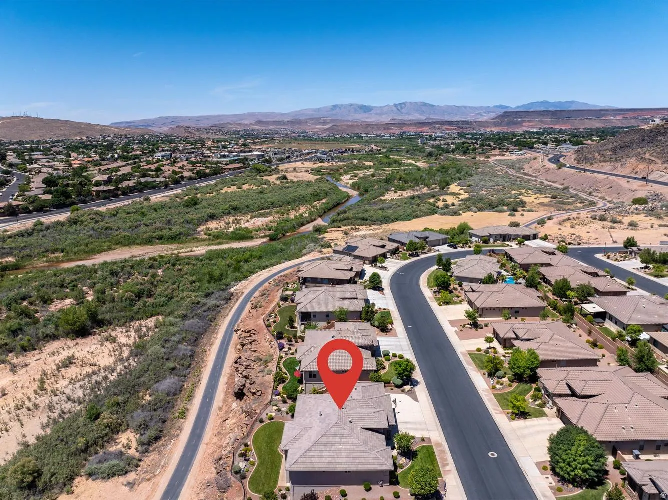 Aerial overview showcasing a residential community with single-story homes and landscaped yards