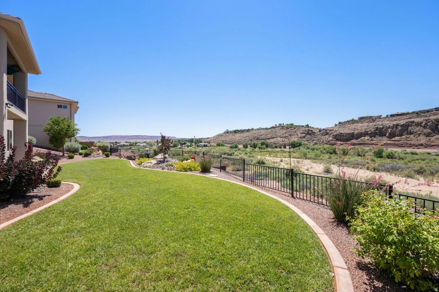 Expansive terraced yard with a manicured lawn and decorative rock landscaping