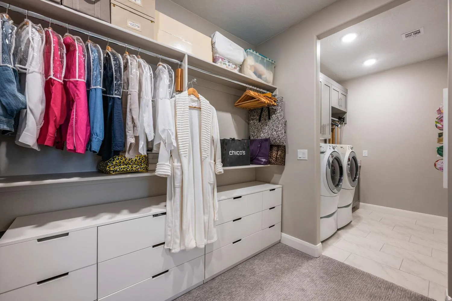 Custom closet system featuring multiple hanging rods and extensive built-in drawer storage