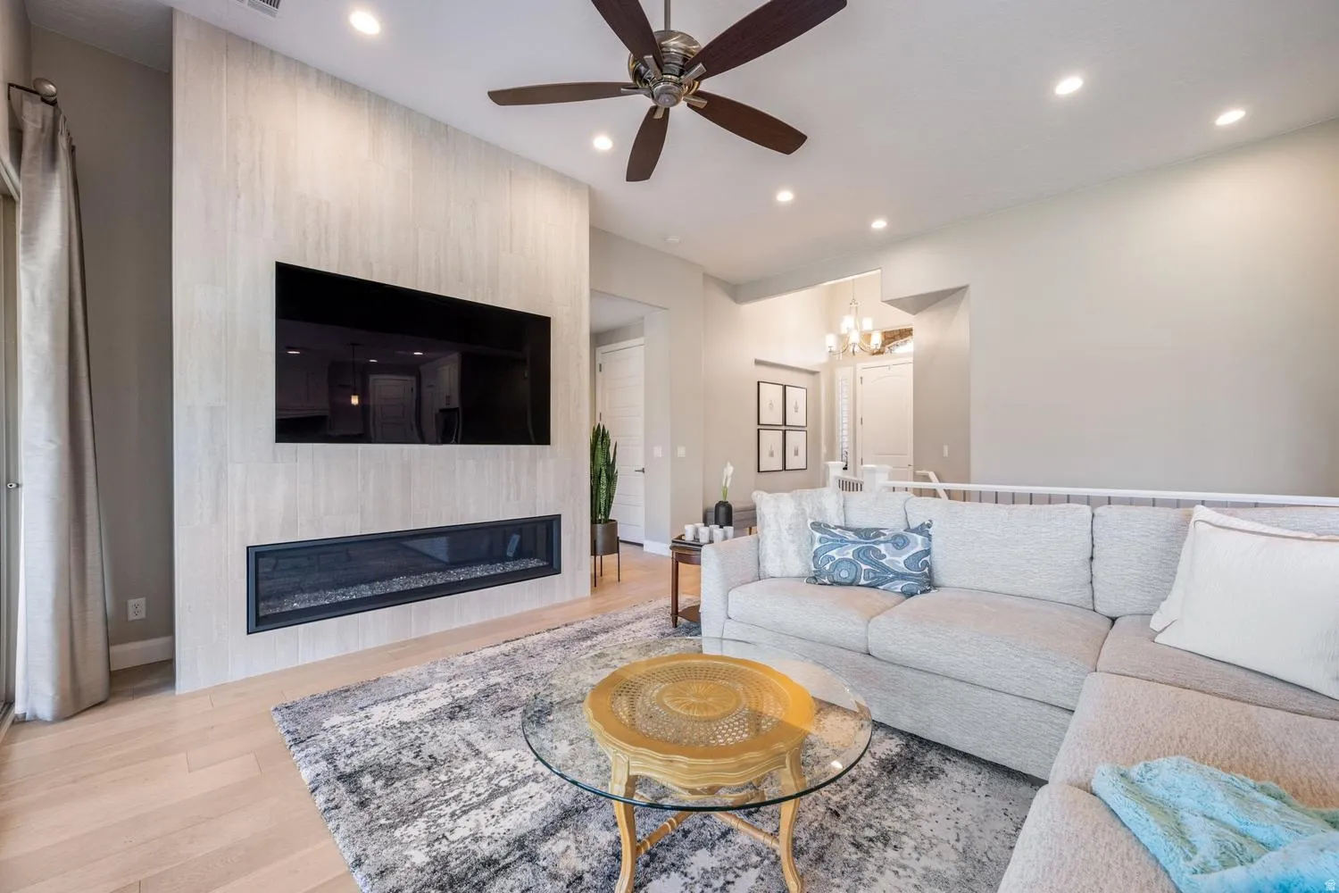 Living area featuring a textured accent wall with a linear fireplace