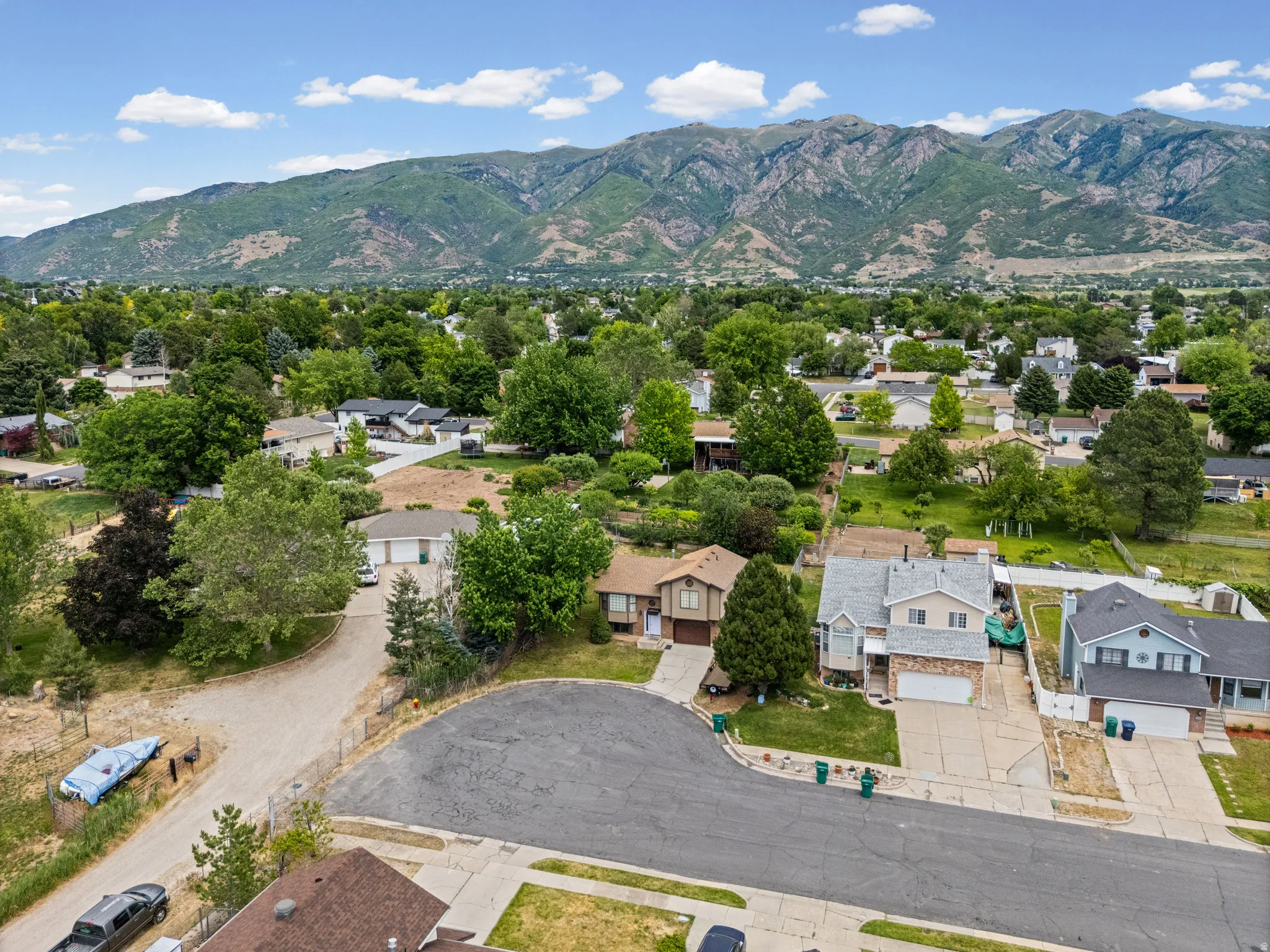 Aerial view of a residential neighborhood with distant mountains under a blue sky with scattered clouds