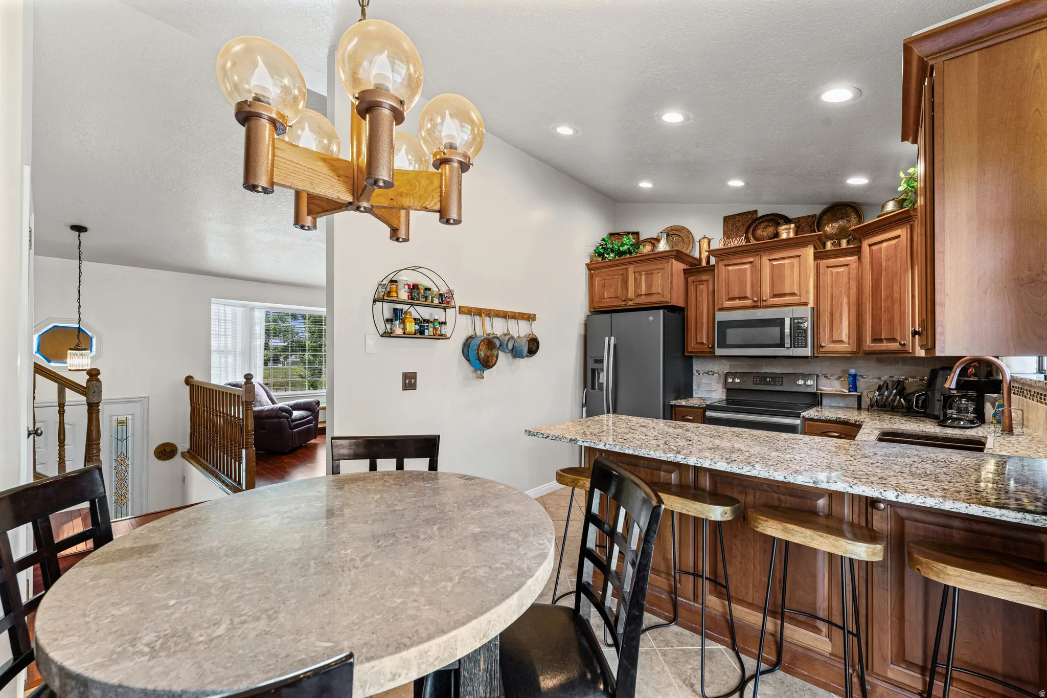 Kitchen featuring wood cabinetry, stainless steel appliances, and a granite-style countertop