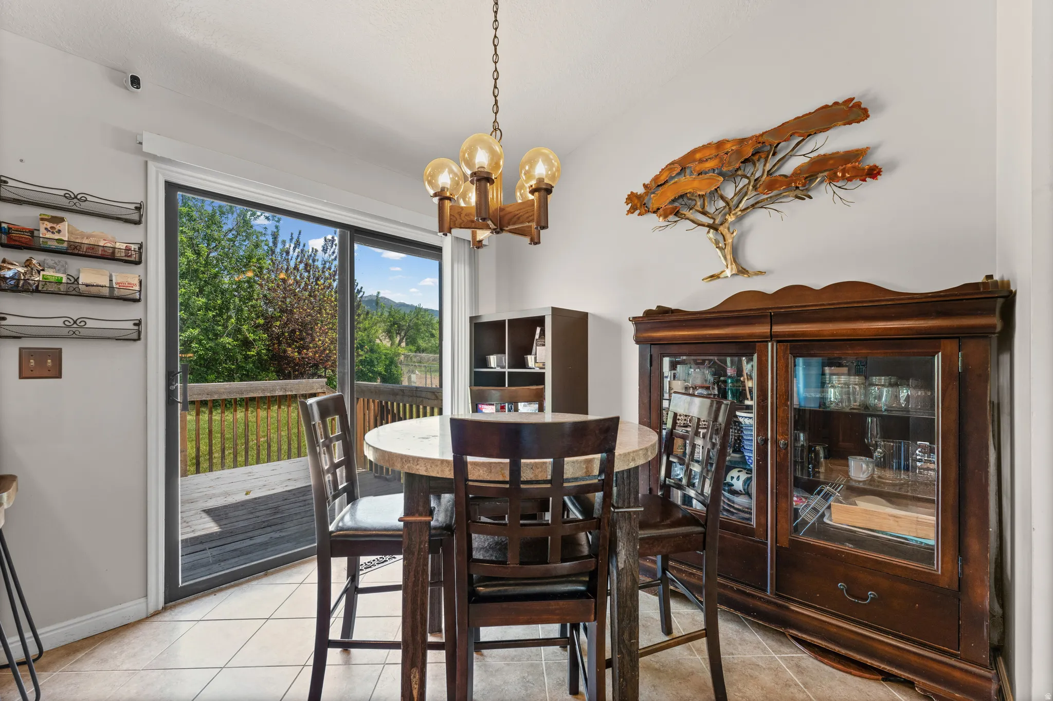 Dining area featuring neutral ceramic tile flooring and a wood chandelier