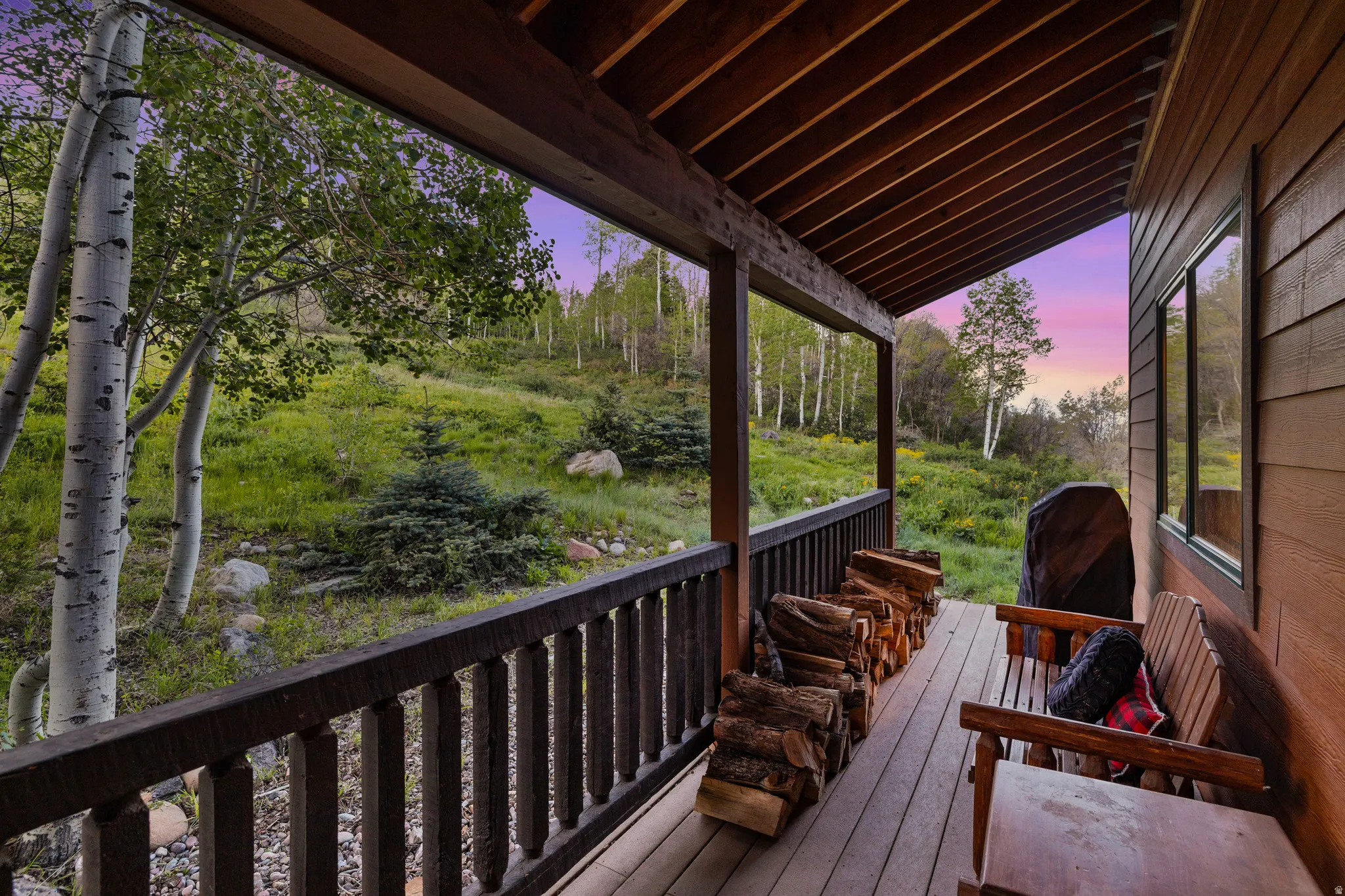 Covered porch featuring wood flooring, wood railing, and a wood ceiling with exposed beams