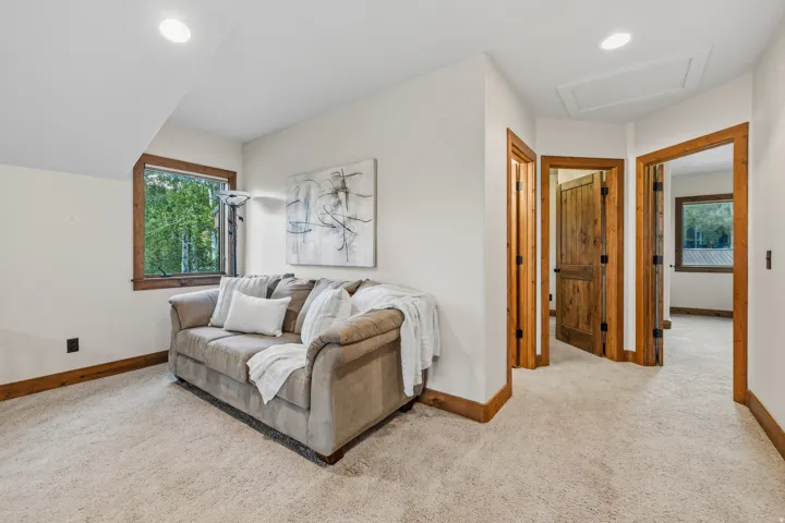 Carpeted interior area featuring natural wood trim, recessed lighting, and multiple paneled wood doors