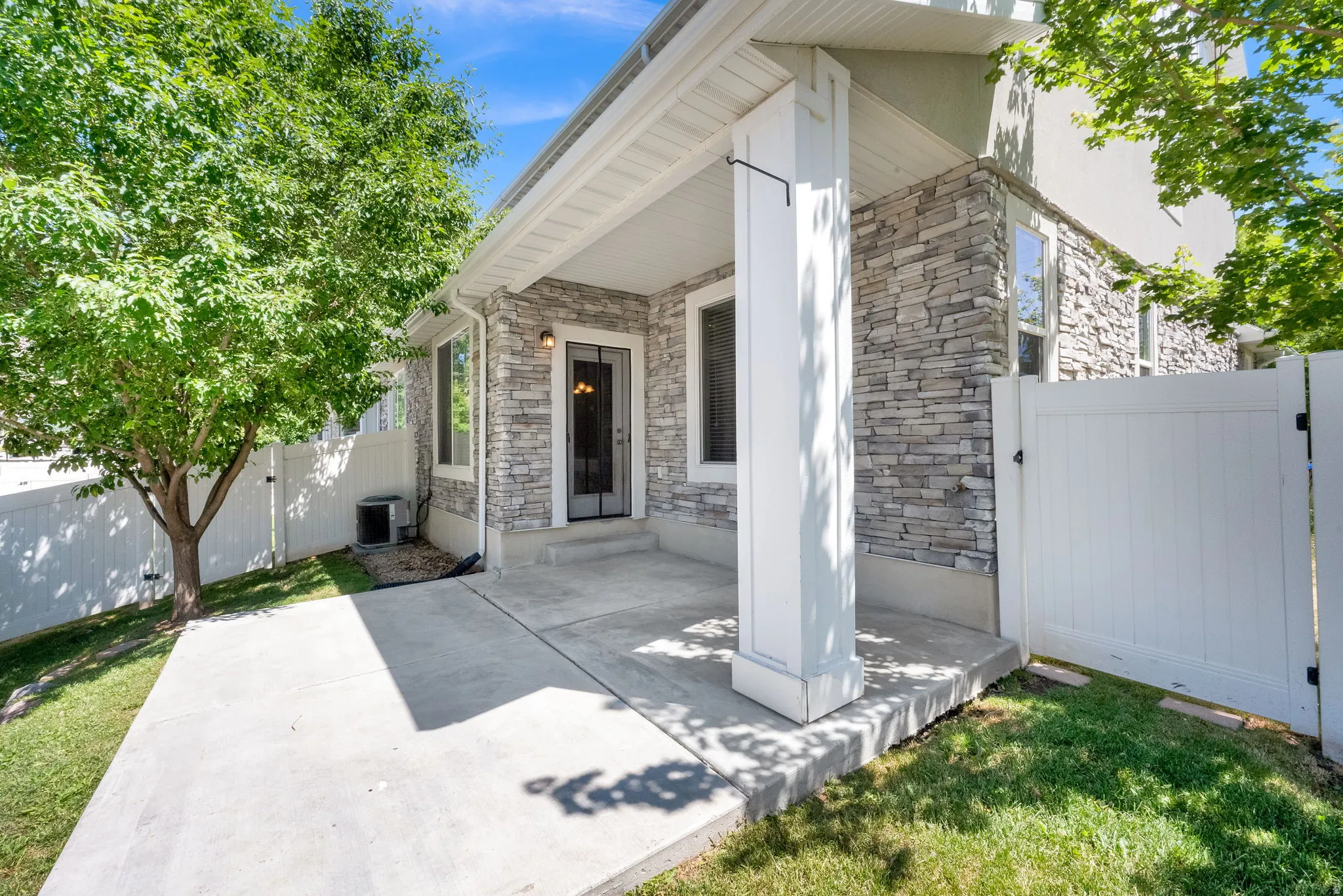 Covered patio featuring a concrete slab and stone veneer exterior